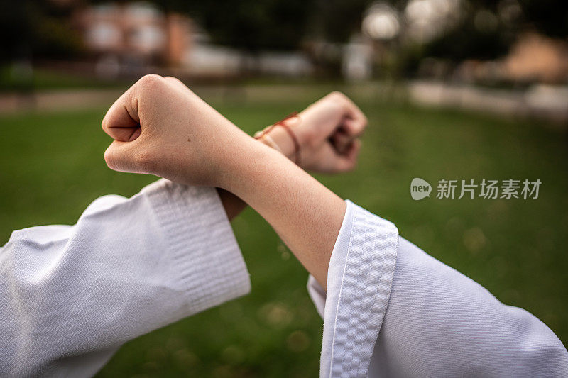 在公园的空手道/跆拳道课上，两只手拳交叉的特写